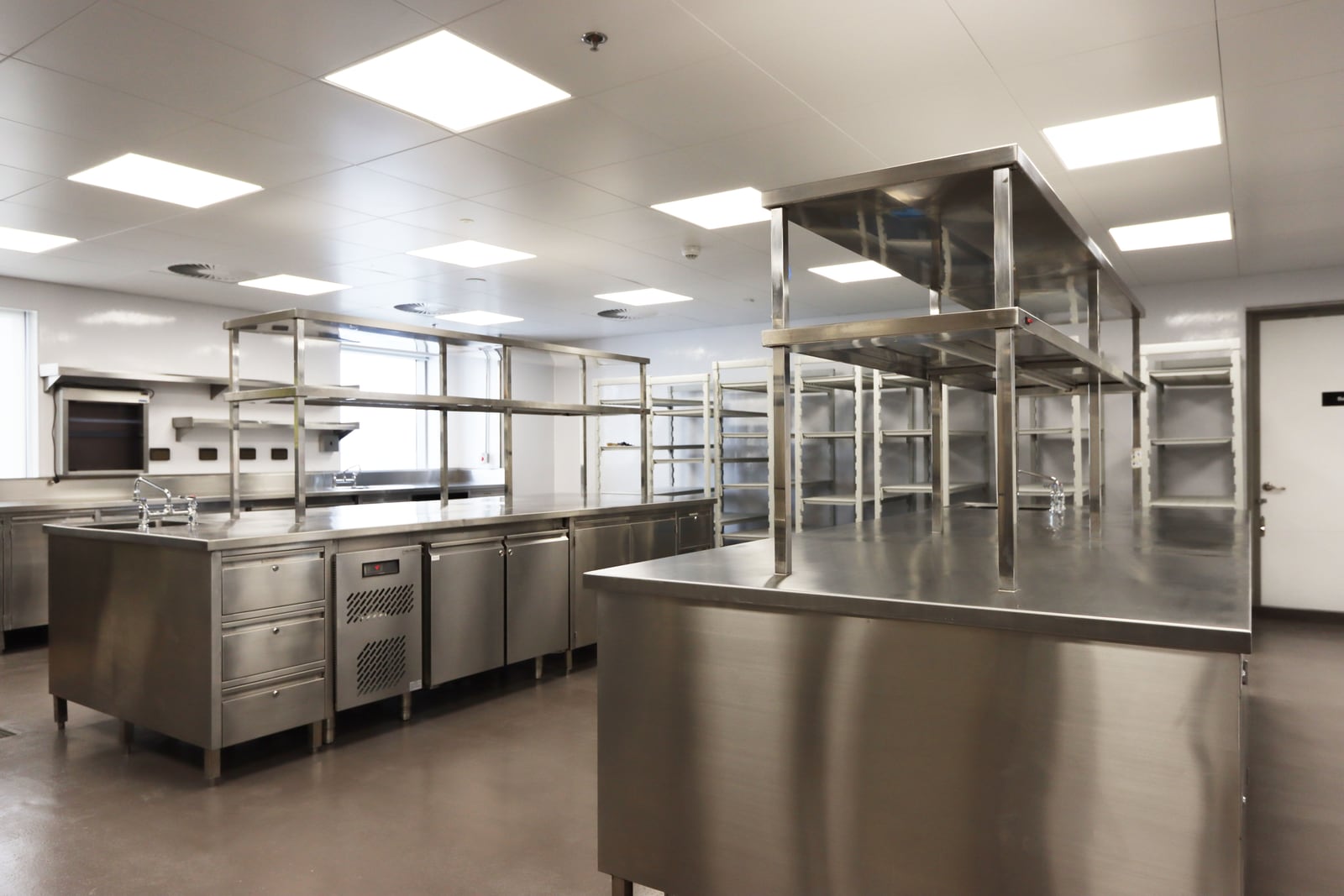 Meta main kitchen with stainless counters, shelving, and preparation surfaces