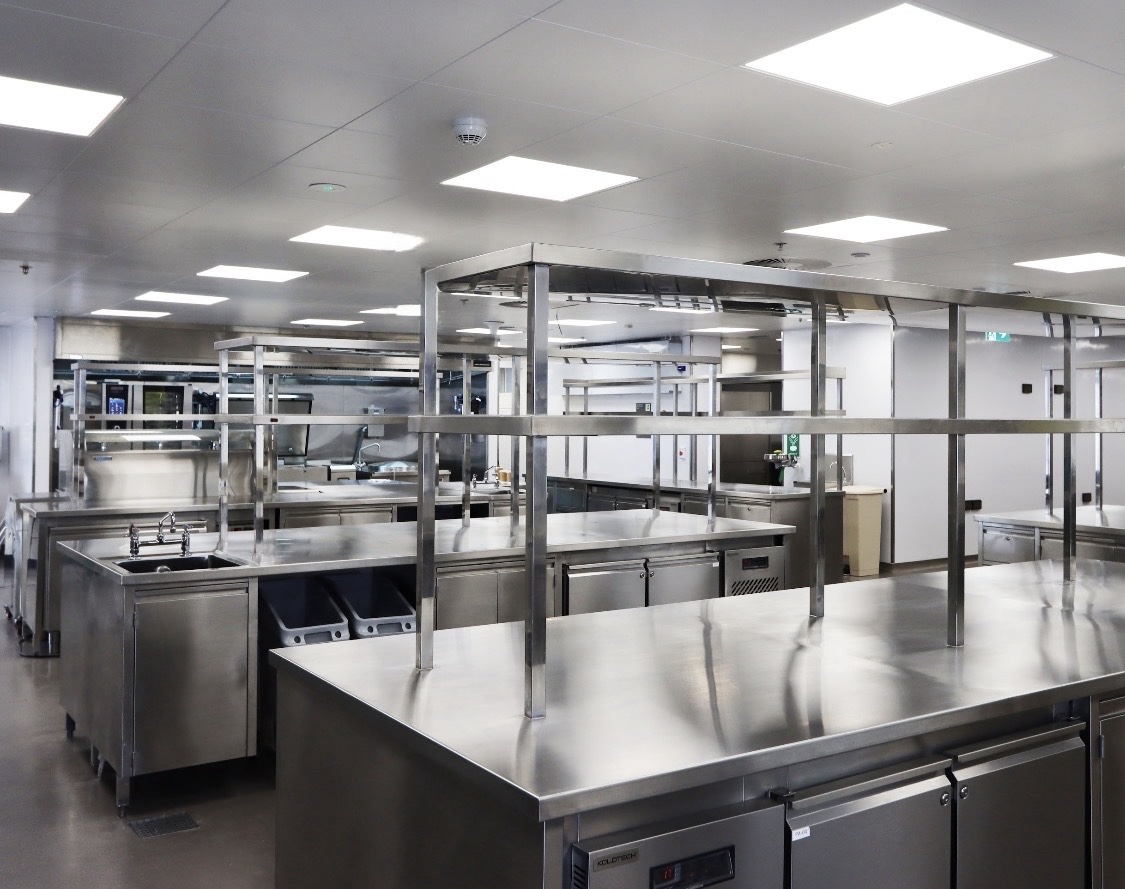 Commercial kitchen stainless worktables and counter surfaces.